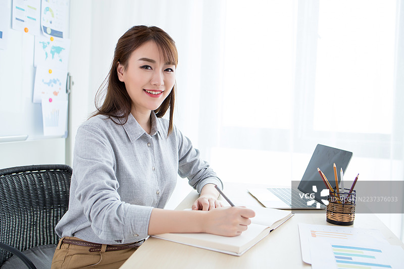 微笑的女商人在桌子前工作图片素材