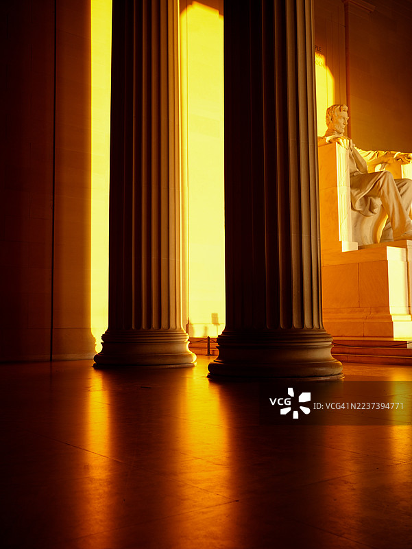 华盛顿特区林肯纪念堂内，亚伯拉罕·林肯雕像和柱子在戏剧性的光线下被照亮，地点：华盛顿，美国图片素材