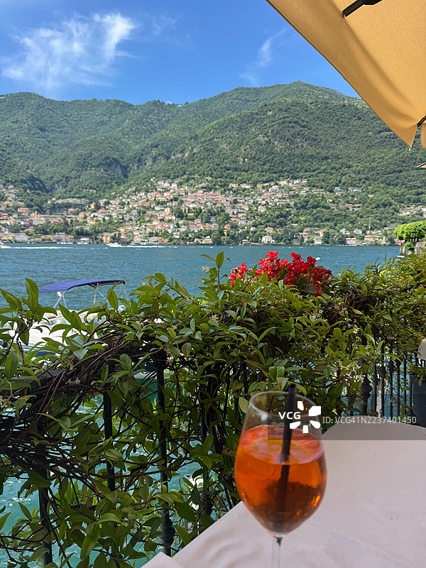 意大利科莫湖畔的山脉风景映衬下的桌上清爽饮品图片素材