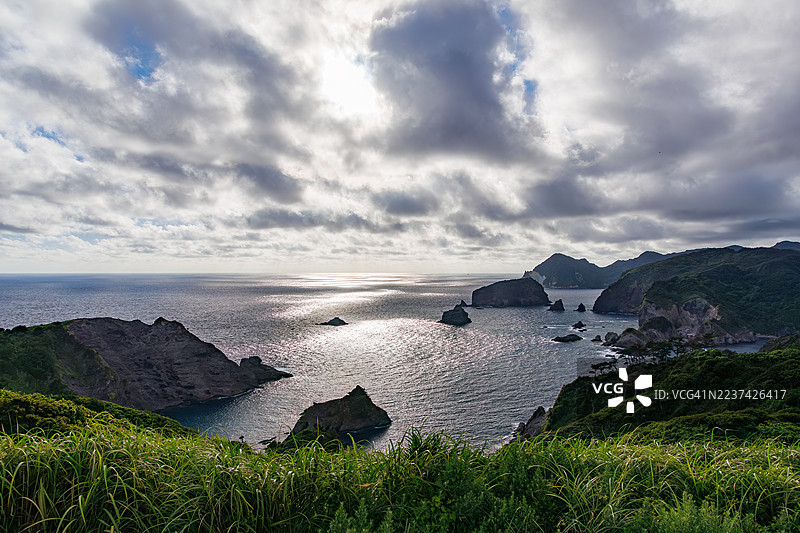 位于伊豆半岛最南端的奥宇津崎的夕菅公园俯瞰着平磯海滩。初夏时,珍贵的香橙百合、长黄百合和巴罗尼香橙百合在山坡上盛开。图片素材