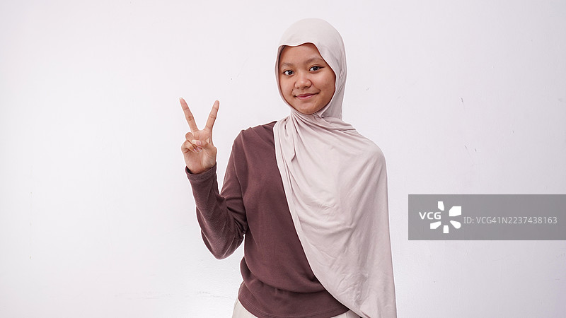 快乐的戴头巾女孩用手指数数。孤立在白色背景上图片素材