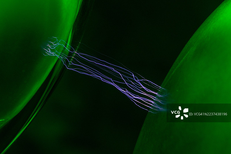 范德格拉夫起电机的不锈钢穹顶与接地的不锈钢球之间的静电弧图片素材