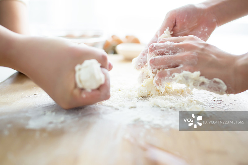 两个人在木桌上揉面团图片素材