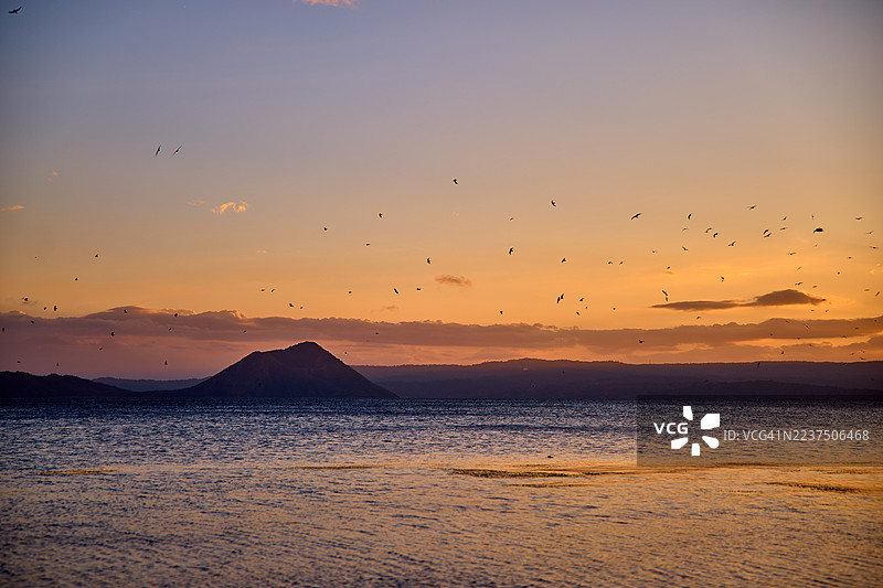 菲律宾塔尔湖上宁静的日落，湖面波光粼粼。图片素材