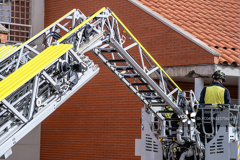 消防员在紧急情况下操作可伸缩梯臂升降机图片素材