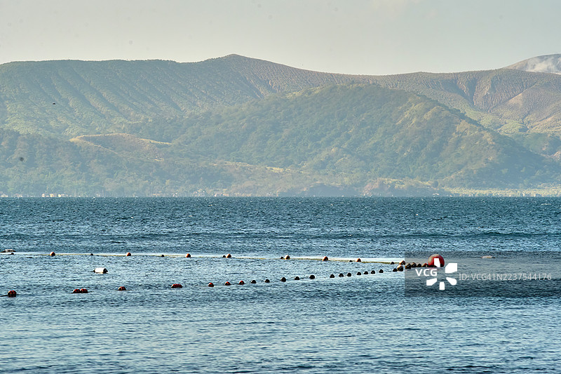 宁静的塔尔湖在广阔的天空下延展。图片素材