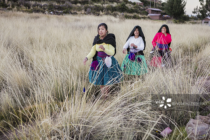 年轻女性在秘鲁的的的喀喀湖塔基莱岛上手工纺羊毛图片素材