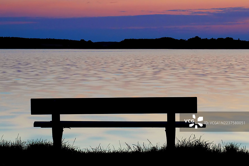湖边的长椅在日落时分图片素材