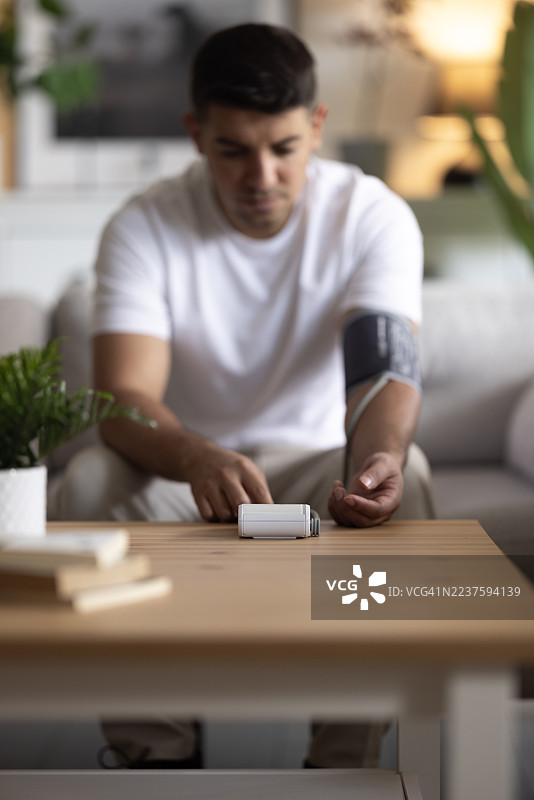 男人在家坐着测量血压图片素材