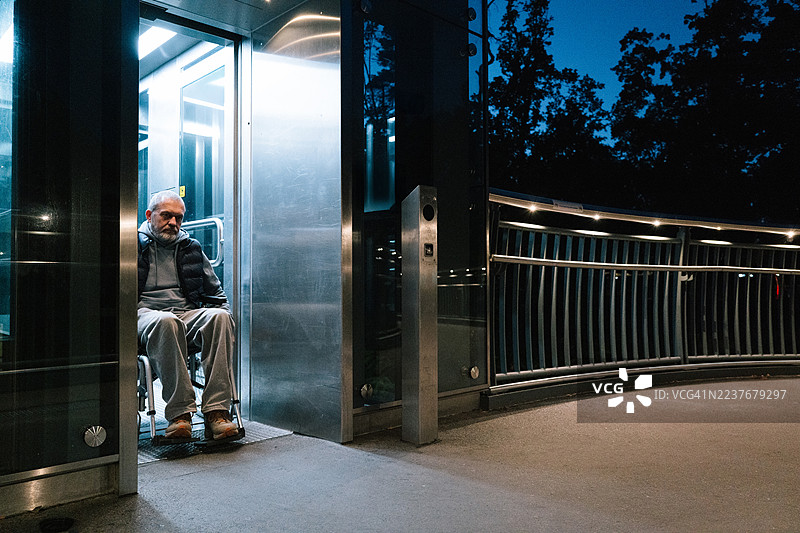 男子使用轮椅升降机进入公共交通工具图片素材
