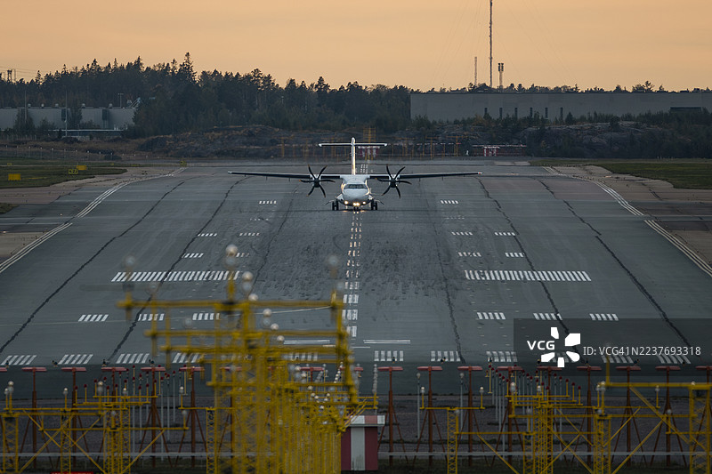 飞机在日落时从跑道起飞图片素材