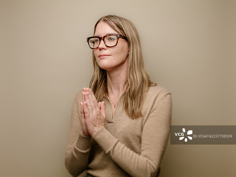 年轻女子双手合十祈祷图片素材