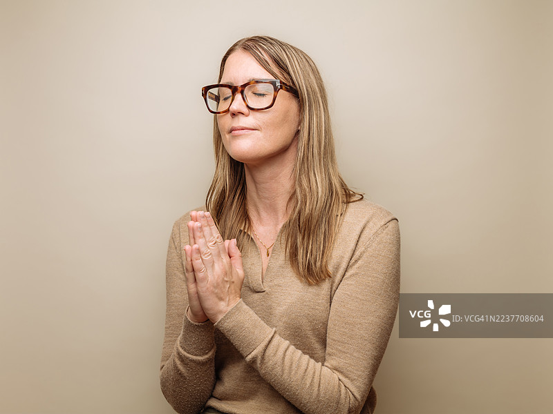 年轻女子双手合十祈祷图片素材