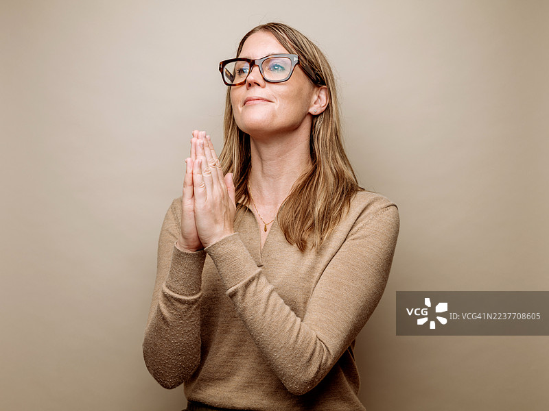 年轻女子双手合十祈祷图片素材
