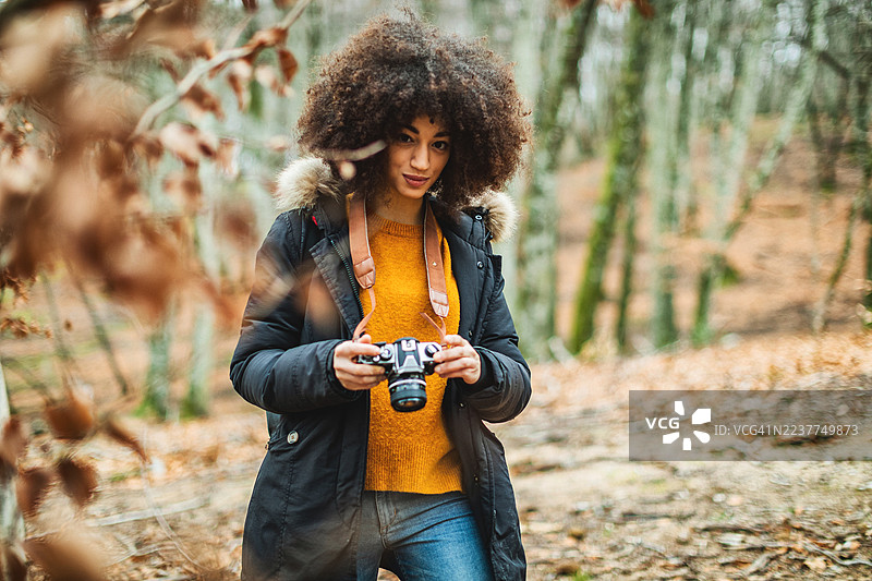 森林中年轻女摄影师的秋季肖像图片素材