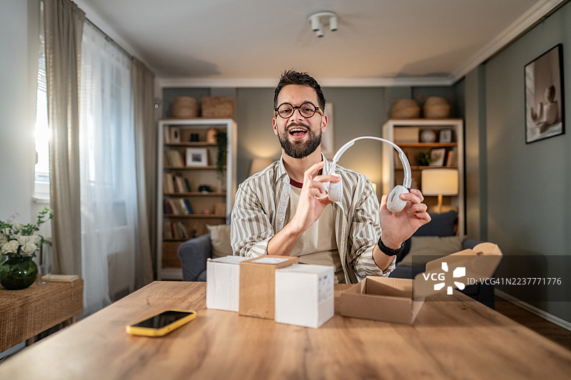 男人拆箱新耳机准备在线评测图片素材