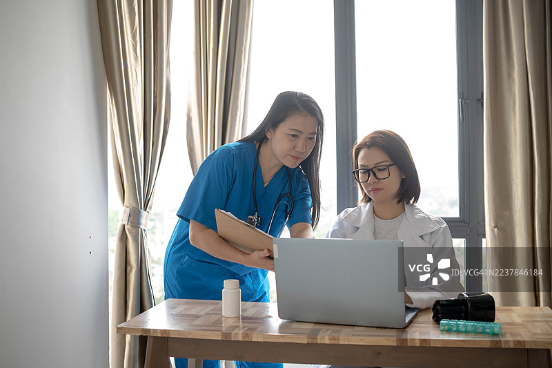 团队合作：两位医生共同审阅健康状况图片素材