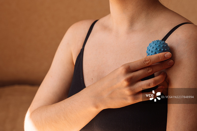用刺球进行肩部自我按摩。图片素材