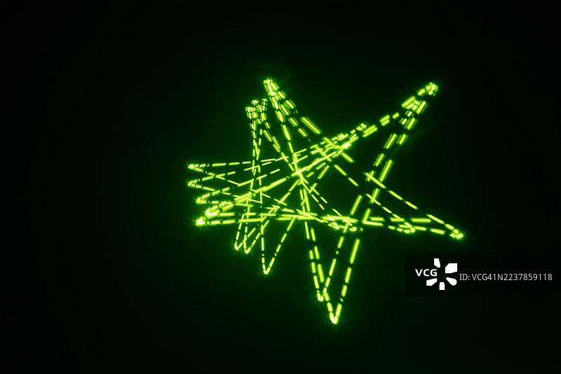 激光灯发出的辉光万花筒图案——由完美的几何曲线和循环组成的复杂网络。图片素材