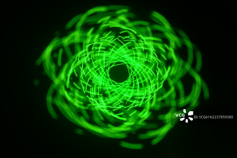 激光灯发出的辉光万花筒图案——由完美的几何曲线和循环组成的复杂网络。图片素材