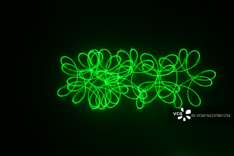 激光灯发光的螺旋仪图案——一个由完美几何曲线和循环组成的复杂网络。图片素材