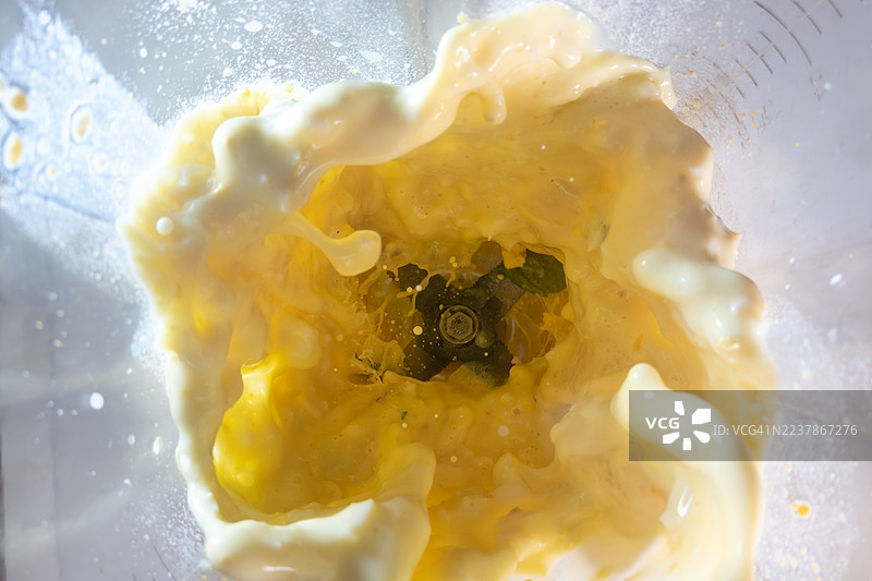 水煮蛋和牛奶，其黄色的蛋黄和白色的蛋白块现在变得苍白而柔软，被卷入了一个剧烈旋转的漩涡中图片素材