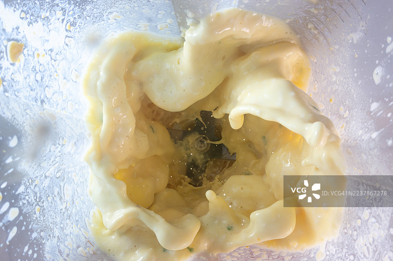 水煮蛋和牛奶，它们黄色的蛋黄和白色的蛋白块现在变得苍白而柔软，被卷入了一个剧烈旋转的漩涡中。图片素材