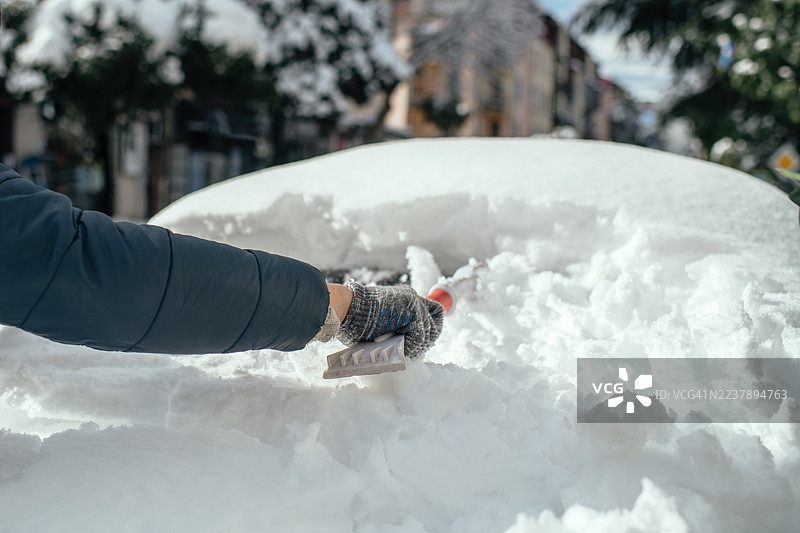 大雪过后，男子正在清洗他的汽车。图片素材