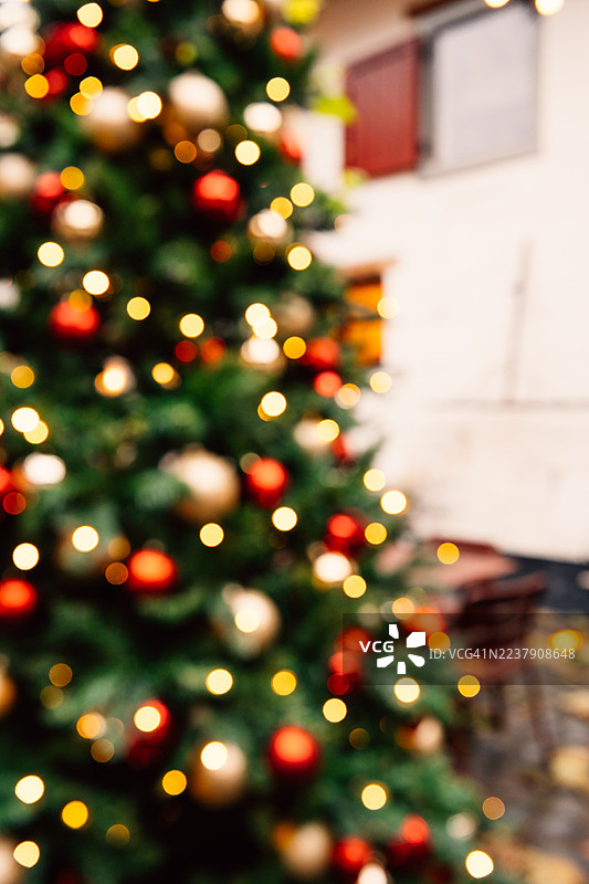 背景虚化的圣诞树，装饰有金色和红色的饰品图片素材