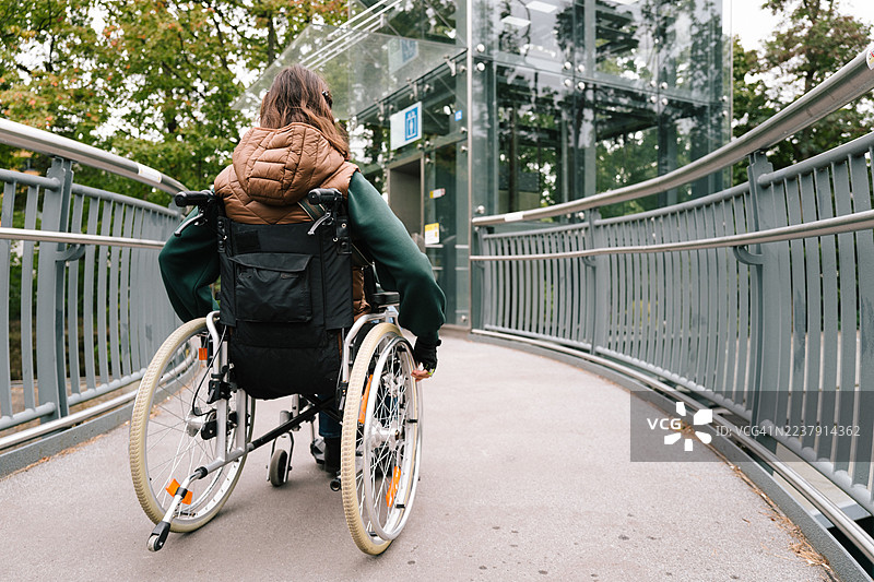 女性使用坡道到达轮椅升降机图片素材