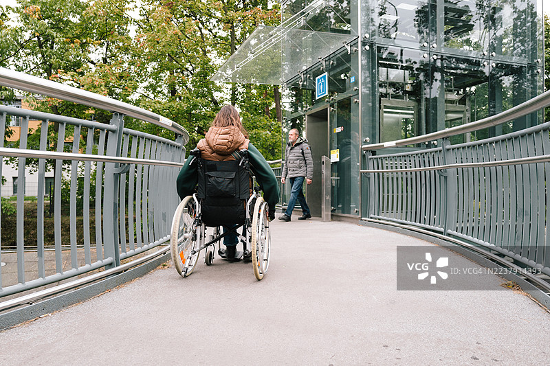 女性使用坡道到达轮椅升降机图片素材