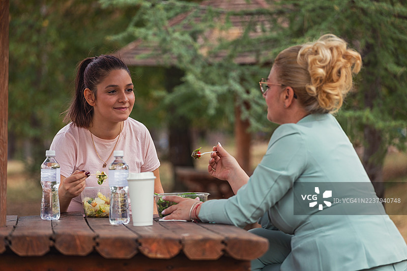 两位职业女性在户外享用午餐休息时间图片素材