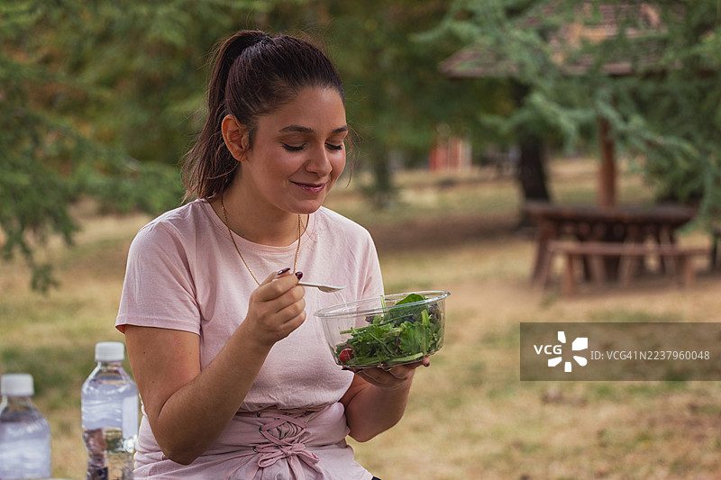 年轻女子在户外享用午餐休息时间图片素材