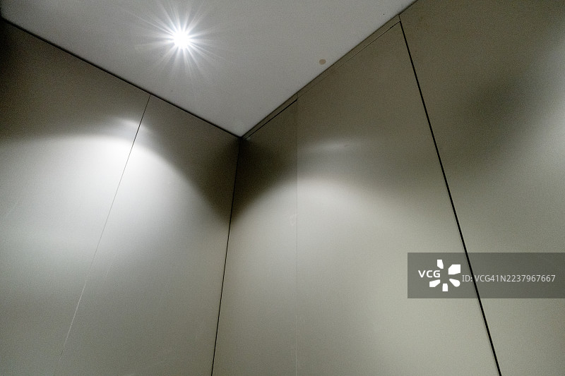 昏暗灯光下的金属电梯内部图片素材