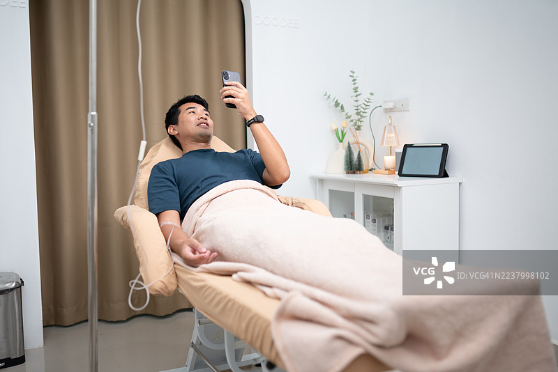 男士在养生诊所接受静脉滴注维生素疗法放松图片素材