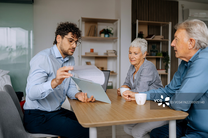 理财顾问在家中咨询老年夫妇图片素材