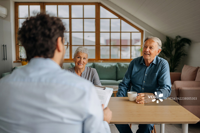 财务顾问在家中咨询一对老年夫妇图片素材