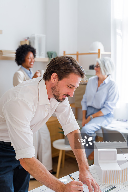 建筑师在创意办公室工作室绘制蓝图图片素材