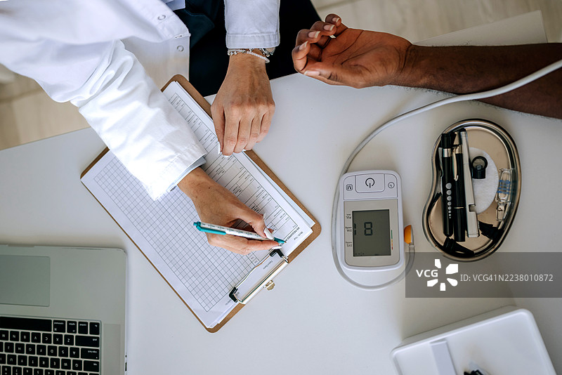 俯视镜头拍摄，女医生正在为男病人测量血压图片素材