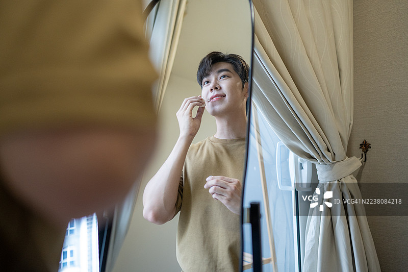 微笑涂抹红色唇彩的男性图片素材