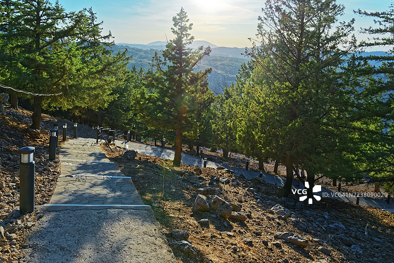 阳光明媚的山区风景，可以看到森林和远景，通往圣母玛利亚·赞比卡（Kyra Psili）教堂的300多级台阶，圣母玛利亚·赞比卡（Kyra Psili）教堂，阿尔汉格洛斯，罗德岛，希腊图片素材