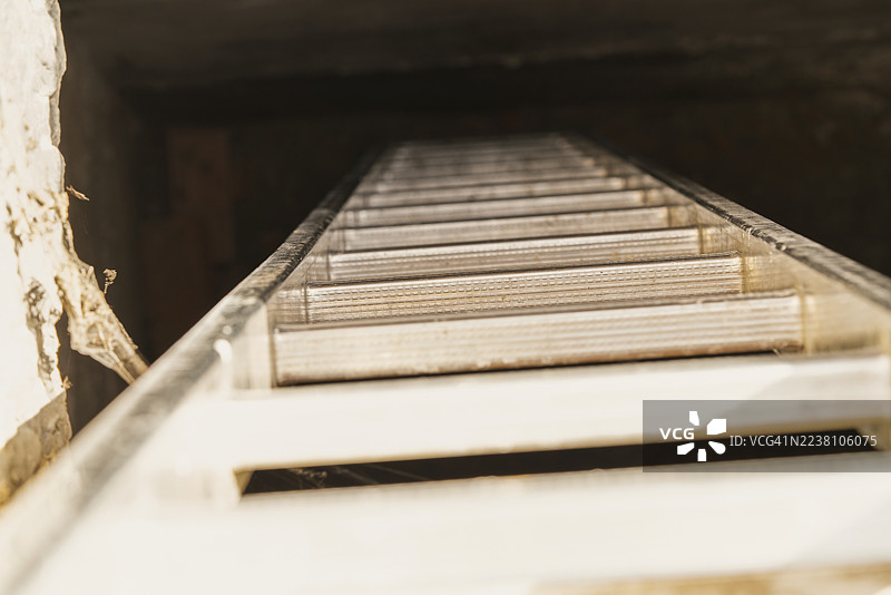 通往黑暗洞穴的梯子，寻找希望。图片素材