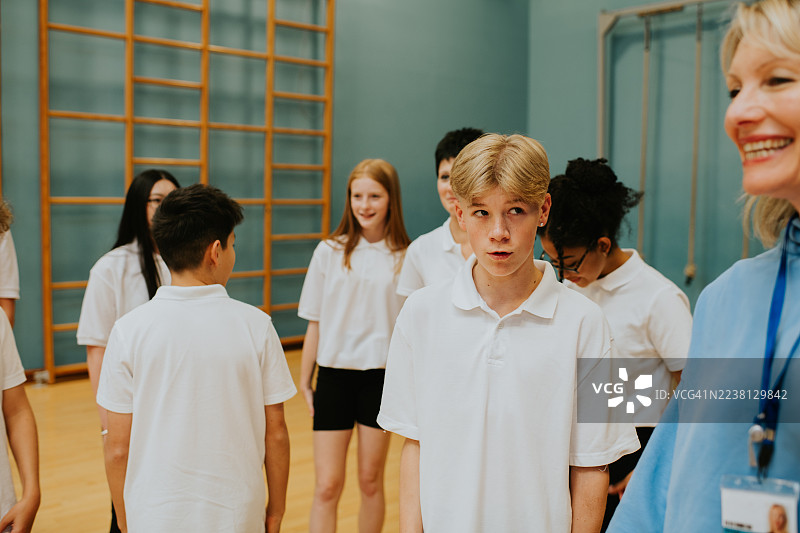 一个小男孩好奇地看着他的女体育老师图片素材