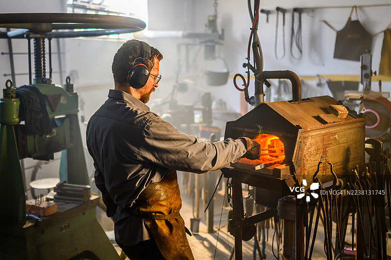 中年工匠在传统锻造环境中工作图片素材
