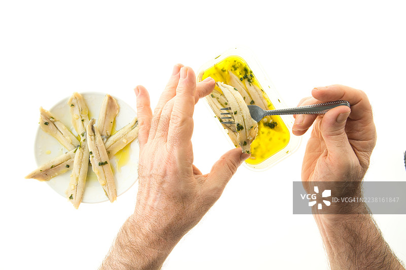 将凤尾鱼放在油醋汁上，摆放在盘中。图片素材