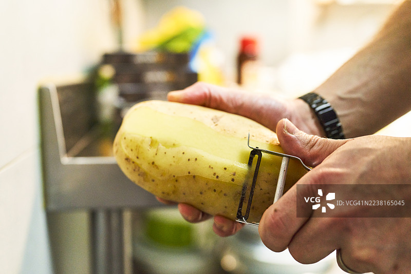 准备烹饪，用手削生土豆皮图片素材