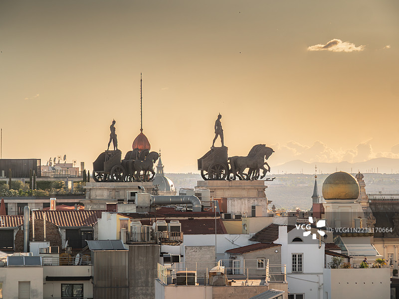 日落时分，马德里市中心区的屋顶特写，可以看到毕尔巴鄂银行大厦，这是一座20世纪的公共建筑，拥有两尊Quadriga青铜雕像，是马德里自治区环境部的所在地——西班牙。图片素材