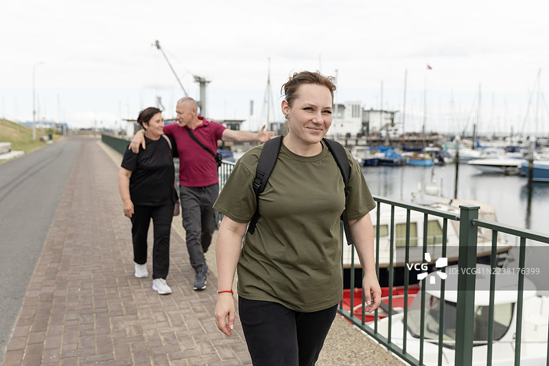 美丽的棕发女子在水滨码头进行一日游图片素材
