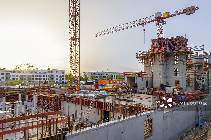 奥格斯堡的建筑工地，夕阳下的起重机和脚手架，展示了住宅开发和节能建筑。图片素材