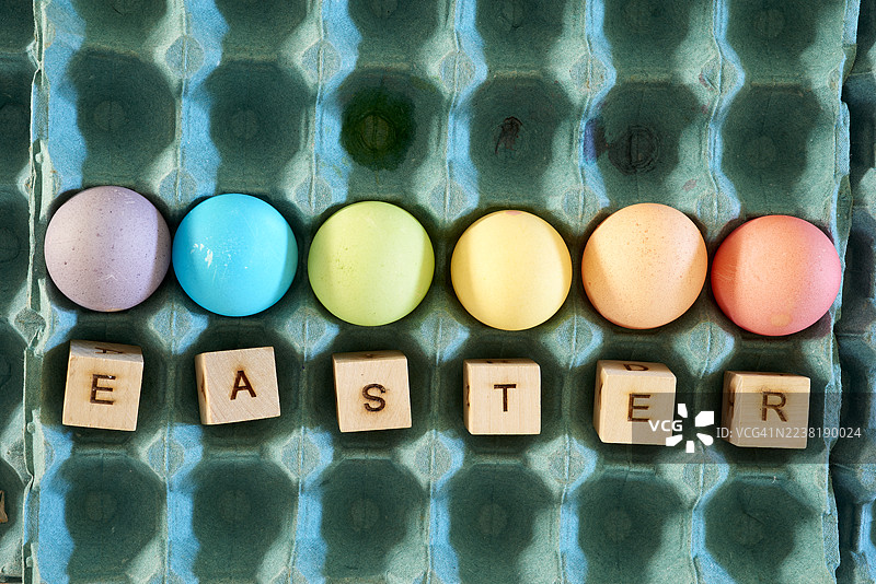 色彩缤纷的复活节彩蛋和拼出复活节字样的木质字母图片素材